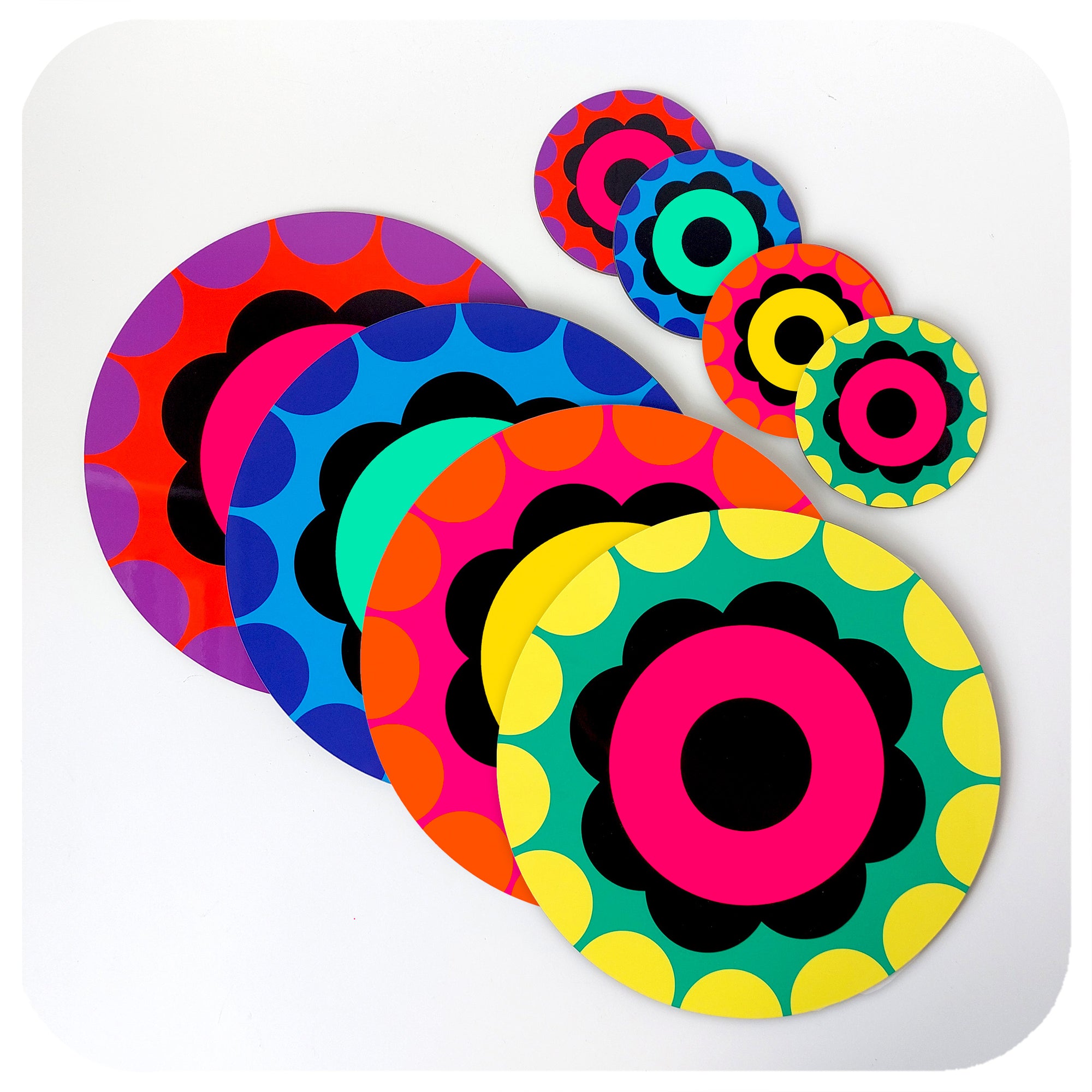 A set of four brightly coloured, 60s style flower placemats in an overlapping row on a white background with a set of matching coasters | The Inkabilly Emporium