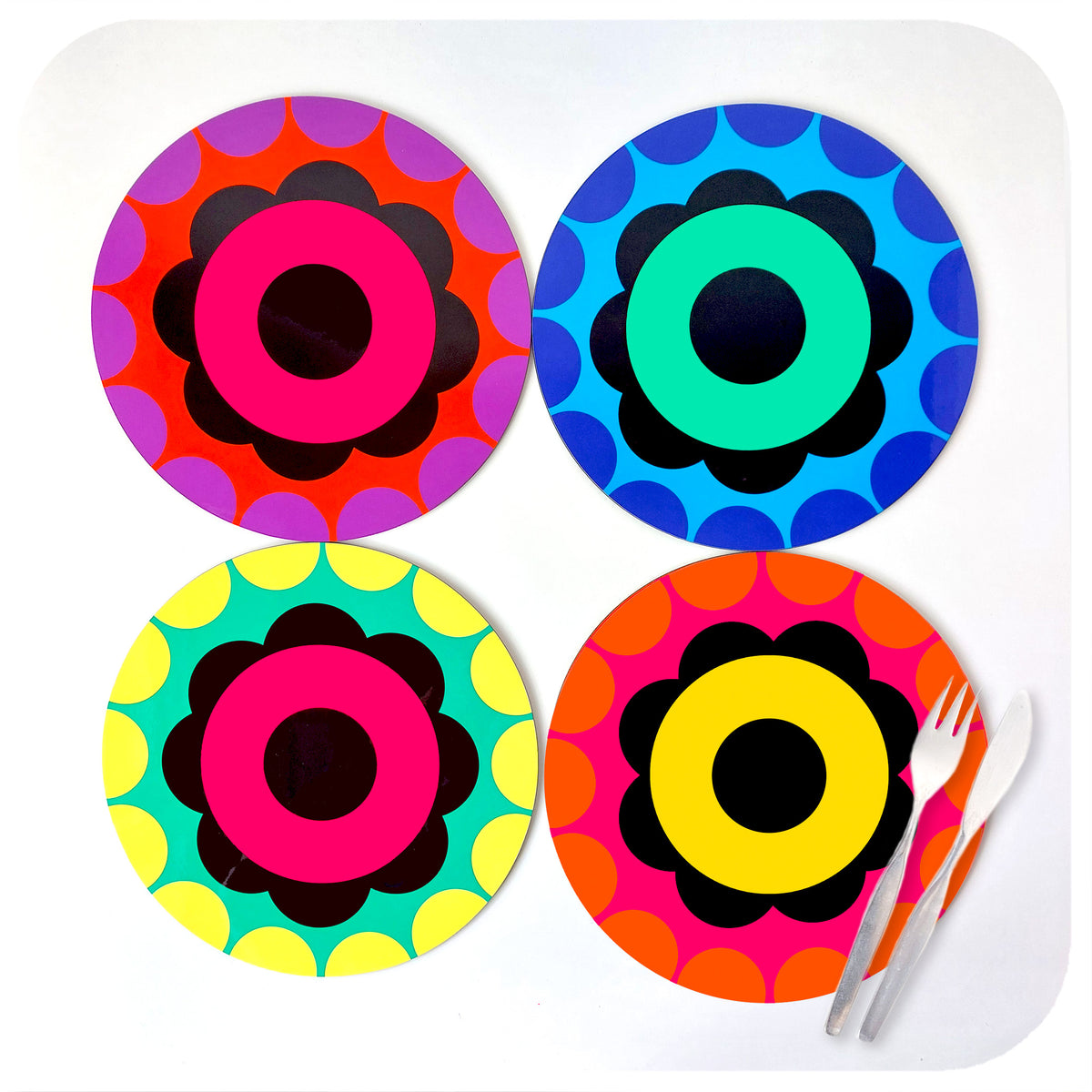 A set of four brightly coloured, 60s style flower placemats on a white background with a set of cutlery | The Inkabilly Emporium