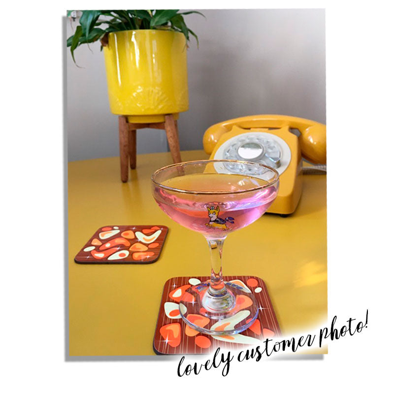 Customer photo of two atomic boomernag coasters with a glass of babycham, yellow vintage telephone and house plant in mid century style planter on a yellow table | The Inkabilly Emporium