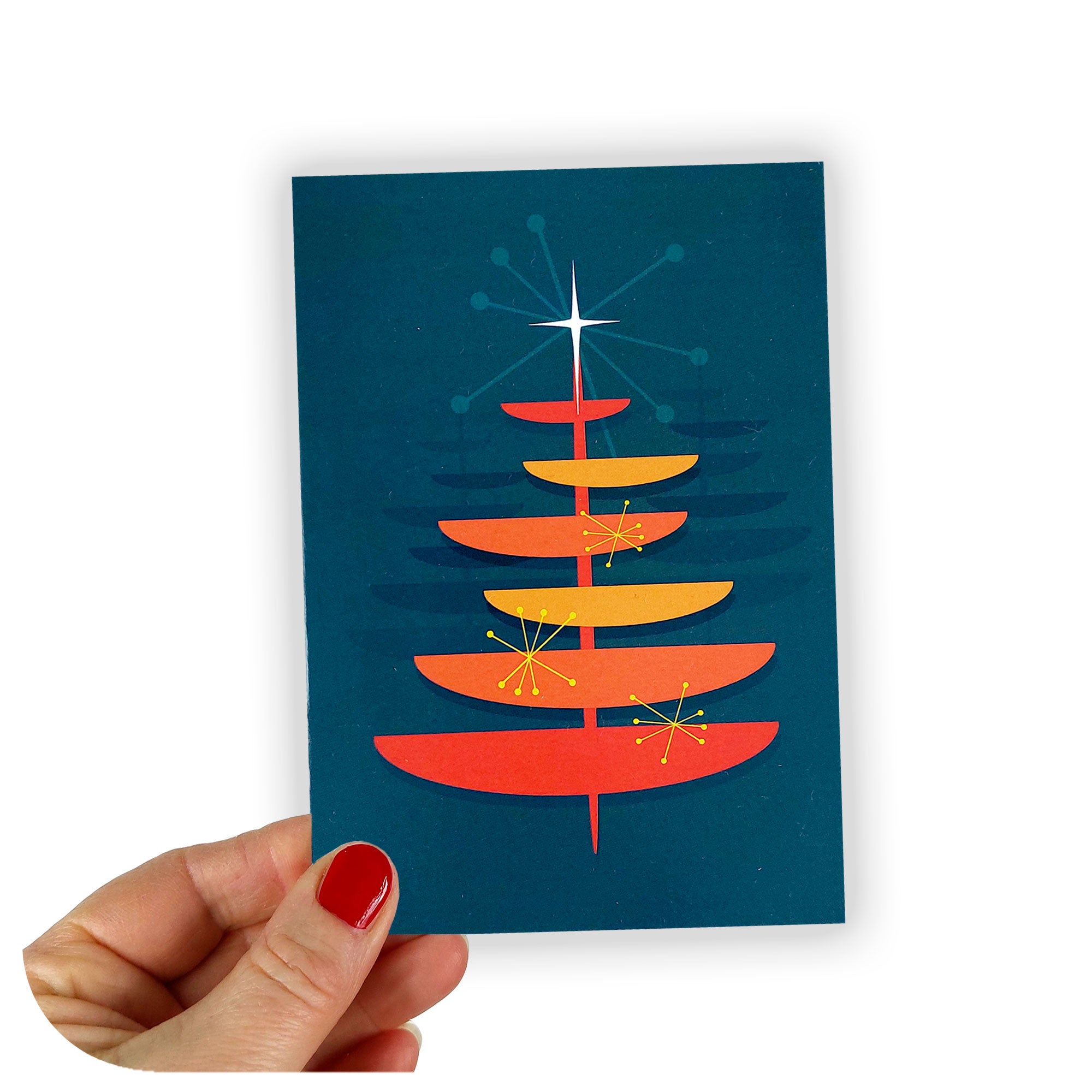 Christmas card held against a white background, featuring a retro / mid century style graphic Christmas Tree