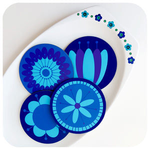 Four round coasters featuring retro style flowers in blues & purples sit in a vintage J & G Meakin dish in similar colours on a white table | The Inkabilly Emporium