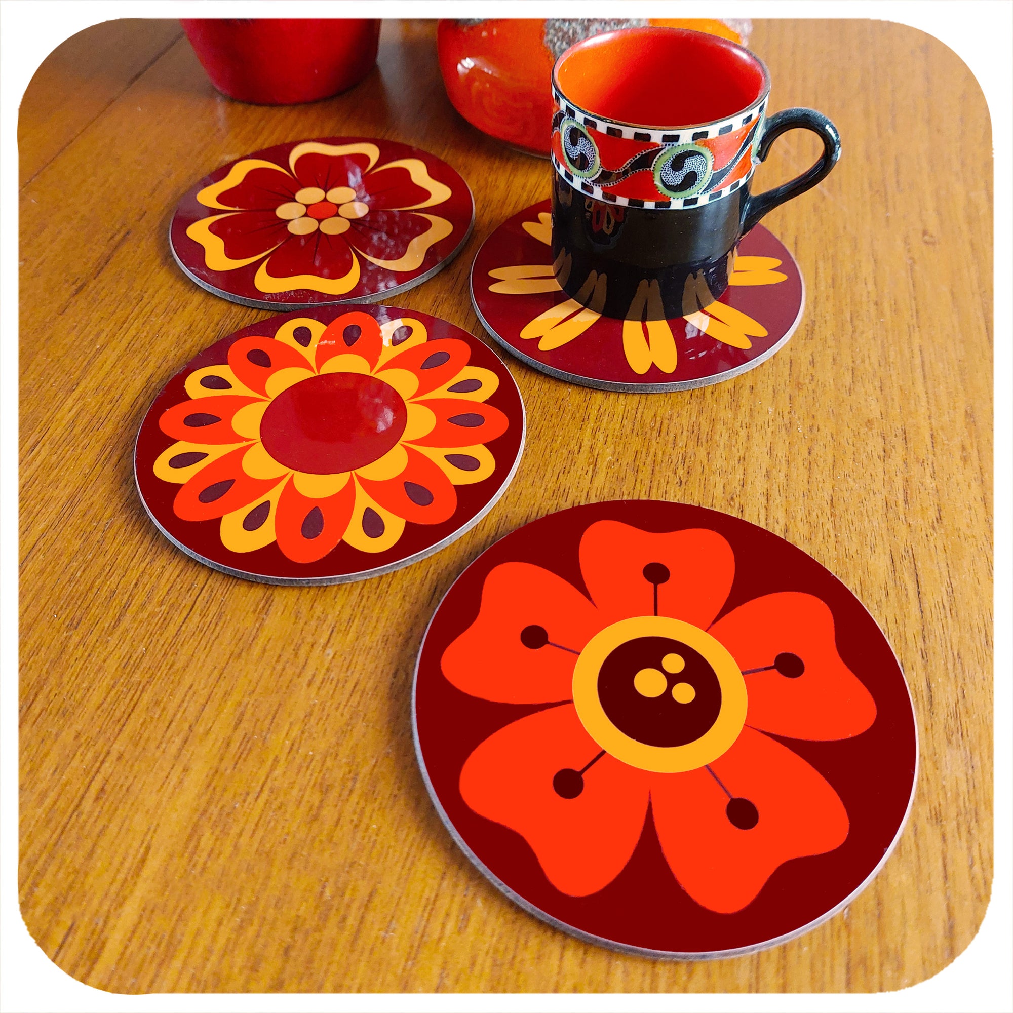 A set of four 70s style floral coasters  scattered on a teak table with vintage espresso mug | The Inkabilly Emporium