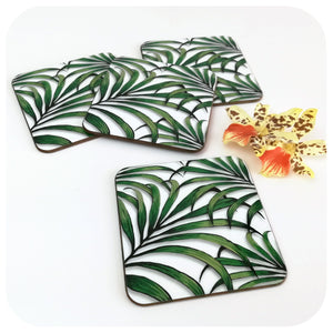 Palm Leaf Coasters, set of 4 scattered on table with tropical flower | The Inkabilly Emporium