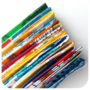 Stack of colourful fabric wristlet key fobs on a white background 
