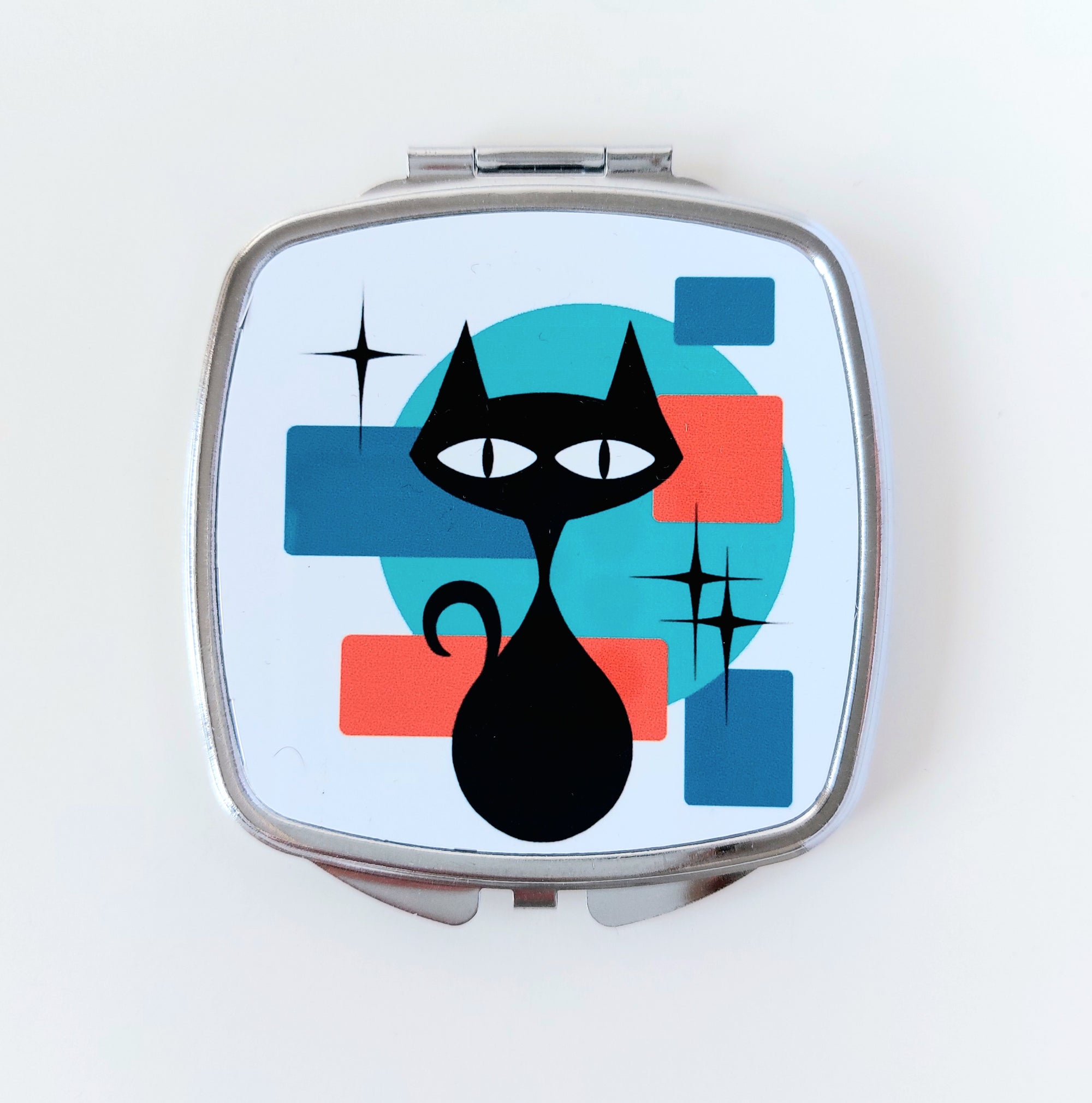 Compact mirror with a black cat design on a white background