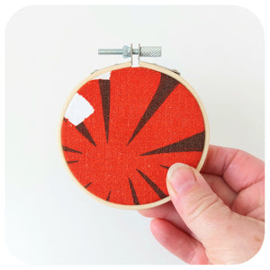 Vintage Fabric Embroidery Hoop held on a white background