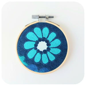 Embroidery hoop with floral design on a white background