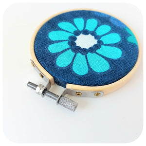 Embroidery hoop with floral design on a white background