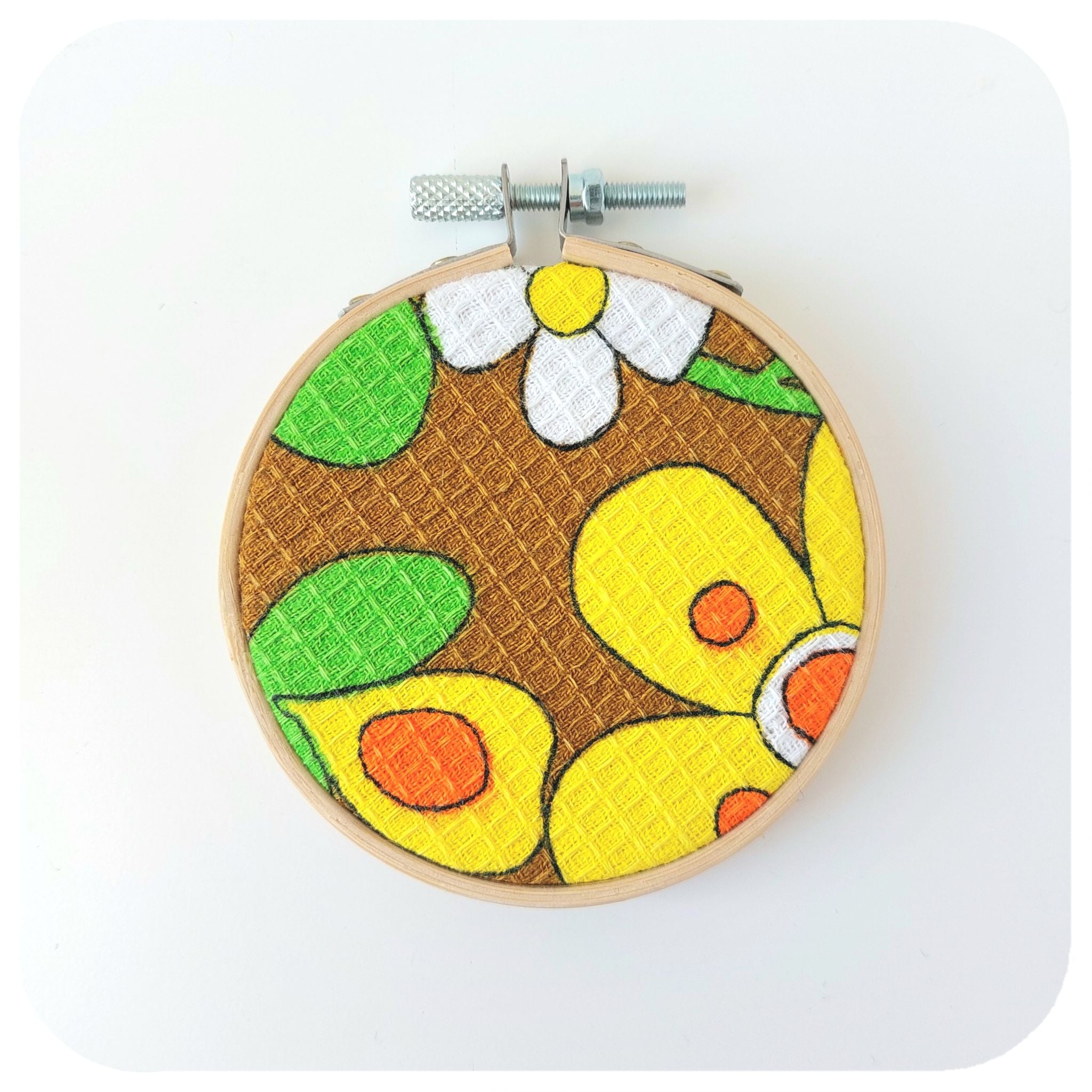 Embroidery hoop with a colourful floral design on a white background