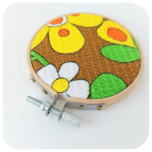 Embroidery hoop with a floral design on a white background