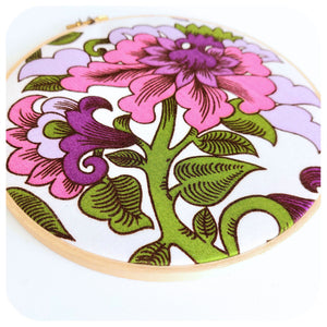 Embroidery hoop with floral design on a white background