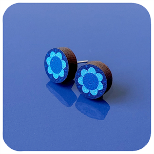 Wooden earrings with blue floral design on a blue background