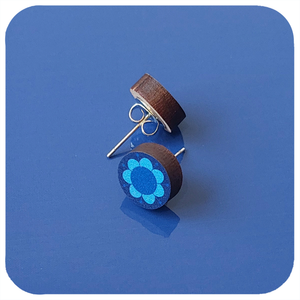 Wooden earrings with blue floral design on a blue background
