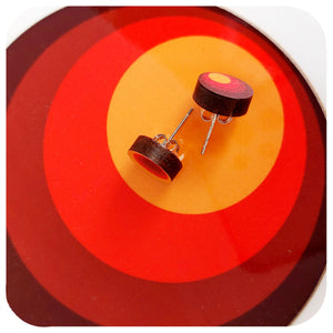 Wooden earrings on a red and orange circular background