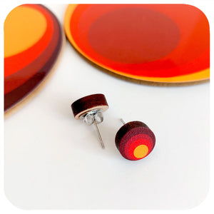 Round earrings with red and yellow design on a white background