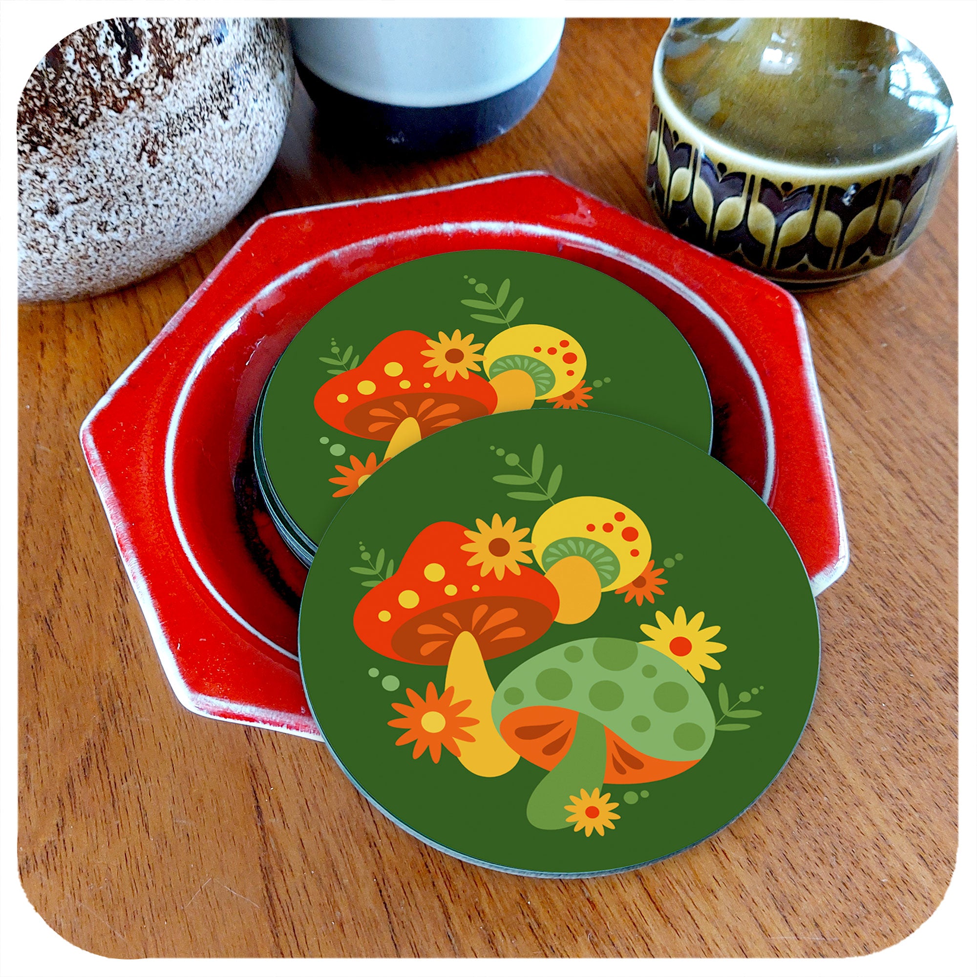 Round 70s style coasters featuring retro mushrooms sit in a Pool Pottery dish, on a teak table next to vintage pottery vases | The Inkabilly Emporium