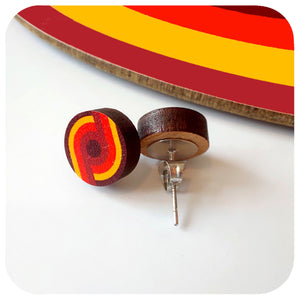 Wooden earrings with red and yellow circular design on a white background