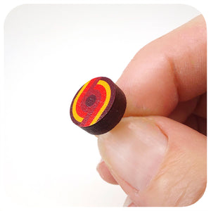 Small round stud earring with red and yellow concentric circles held between fingers against a white background | The Inkabilly Emporium