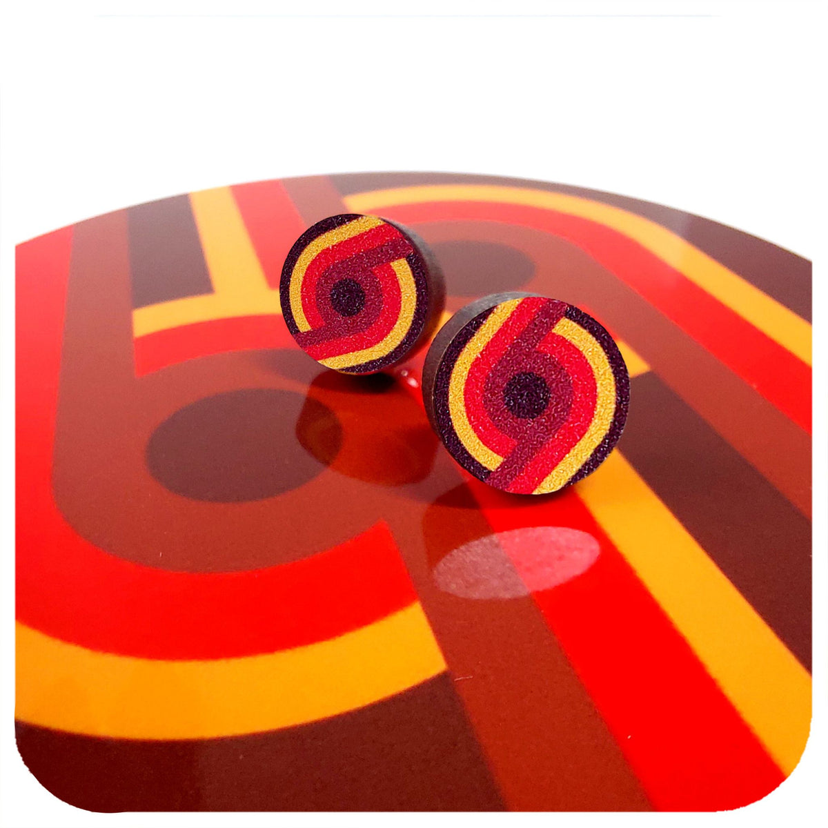 Red and yellow circular earrings on a colourful abstract background | The Inkabilly Emporium