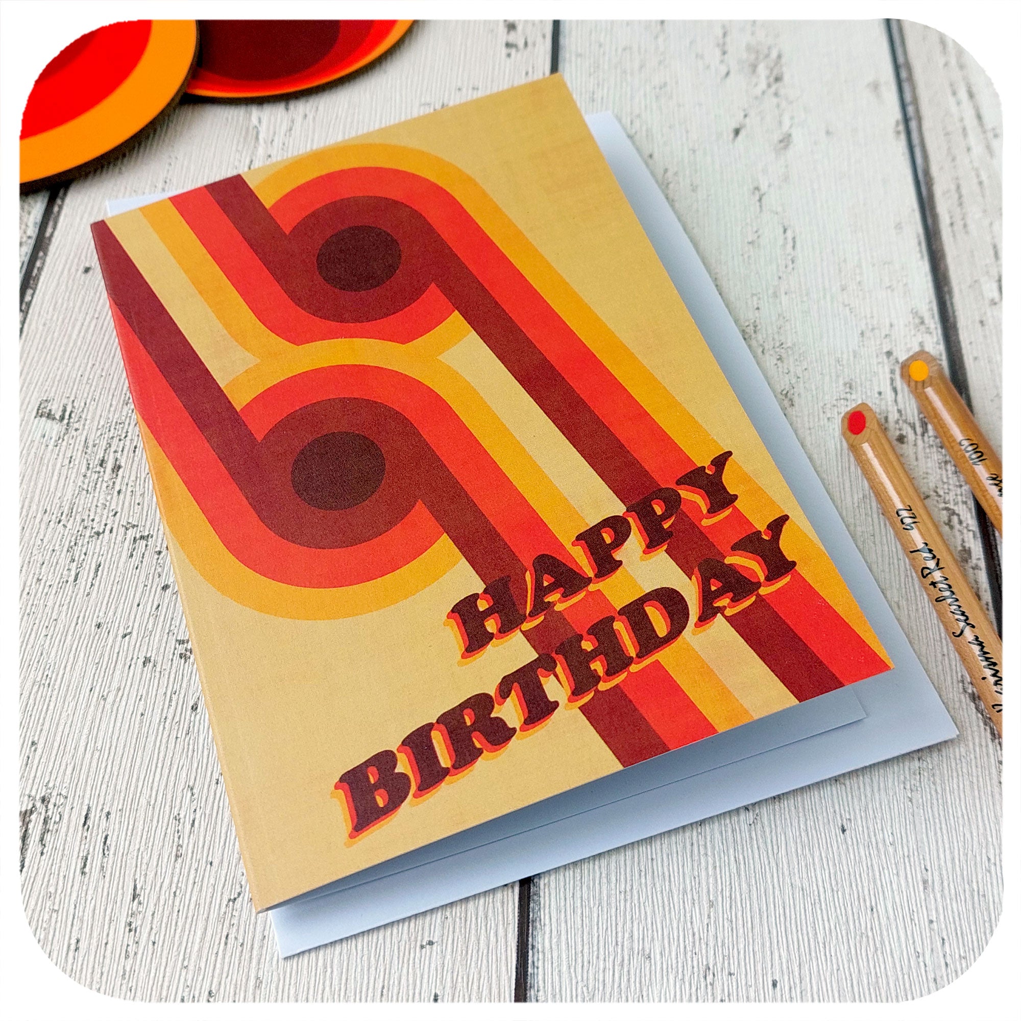 70s Graphic Birthday Card lying on a table with envelope, pencils and retro coasters | The Inkabilly Emporium