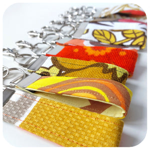 Collection of colourful fabric keychains on a white background