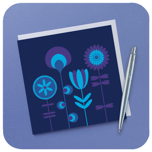 A square card featuring blue & purple scandi style flowers sits with a white envelope and parker pen on a lilac background | The Inkabilly Emporium