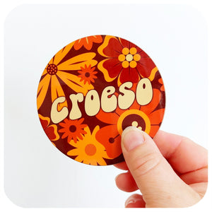 A coasters in a 70s floral design featuring the word Croeso, held against a white background | The Inkabilly Emporium