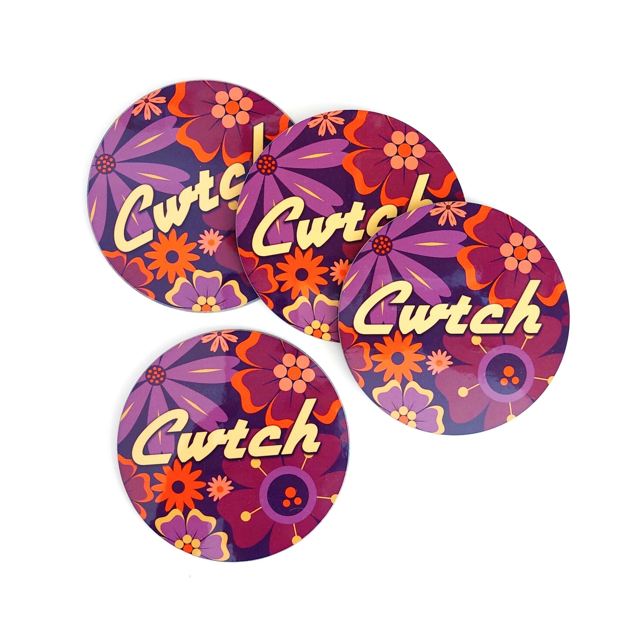 Four round coasters with floral design and 'Cwtch' text on a white background