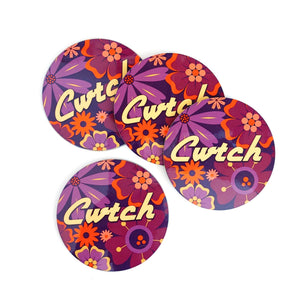 Four round coasters with floral design and 'Cwtch' text on a white background