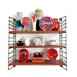 Wooden shelf with decorative items including vases, plates, and a clock on a white background