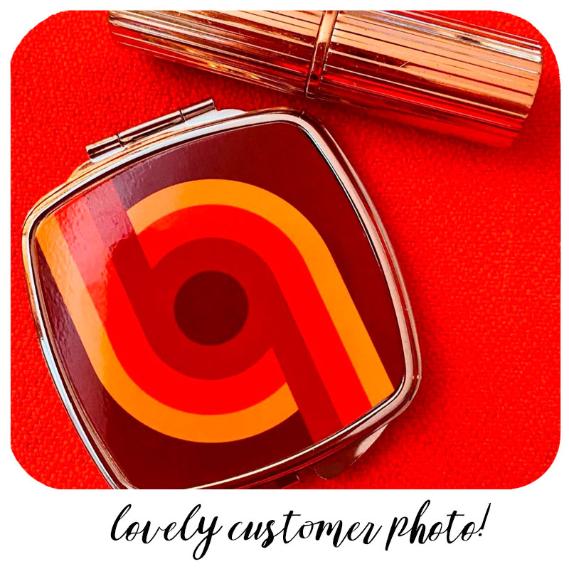 Customer photo of 70s Supergraphic compact mirror with lipstick on a red background | The Inkabilly Emporium