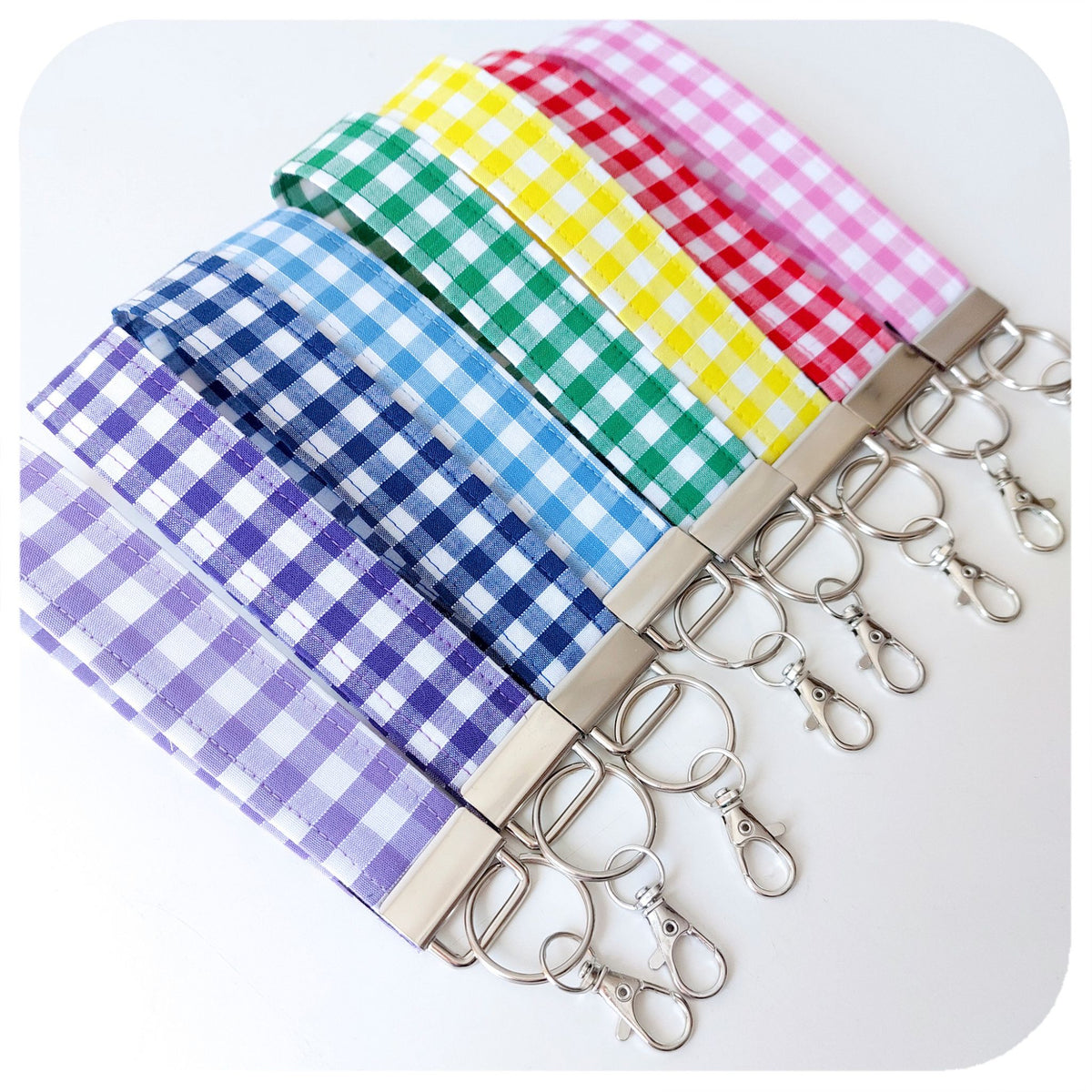 Set of colourful gingham checkered keychains with metal hooks on a white background