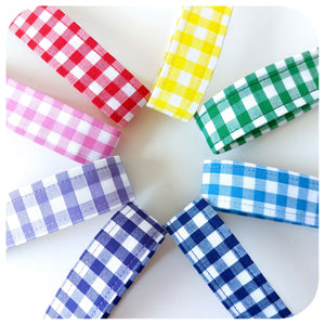 Set of colourful gingham wristlets on a white background, close up of the fabric hoops