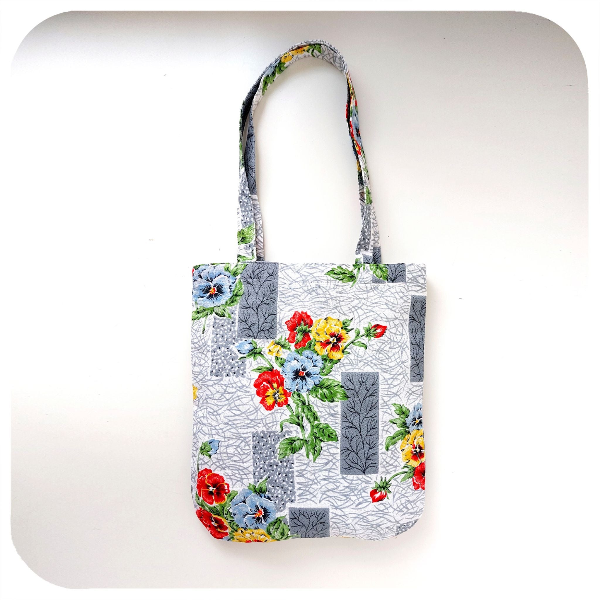 Tote bag with mid century style floral design on a white background