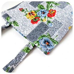 Floral-patterned tote bag with  flowers and grey accents on a white background 