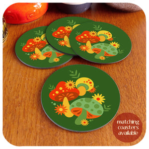 A set of four round vintage style mushroom coasters sit on a teak table with vintage pottery pieces in the background. Text in the corner reads "matching coasters available" | The Inkabilly Emporium