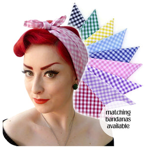 Woman wearing a checkered gingham headscarf with additional colourful bandanas displayed.