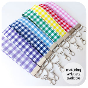 Set of colorful gingham keychains with matching wristlets on a white background.