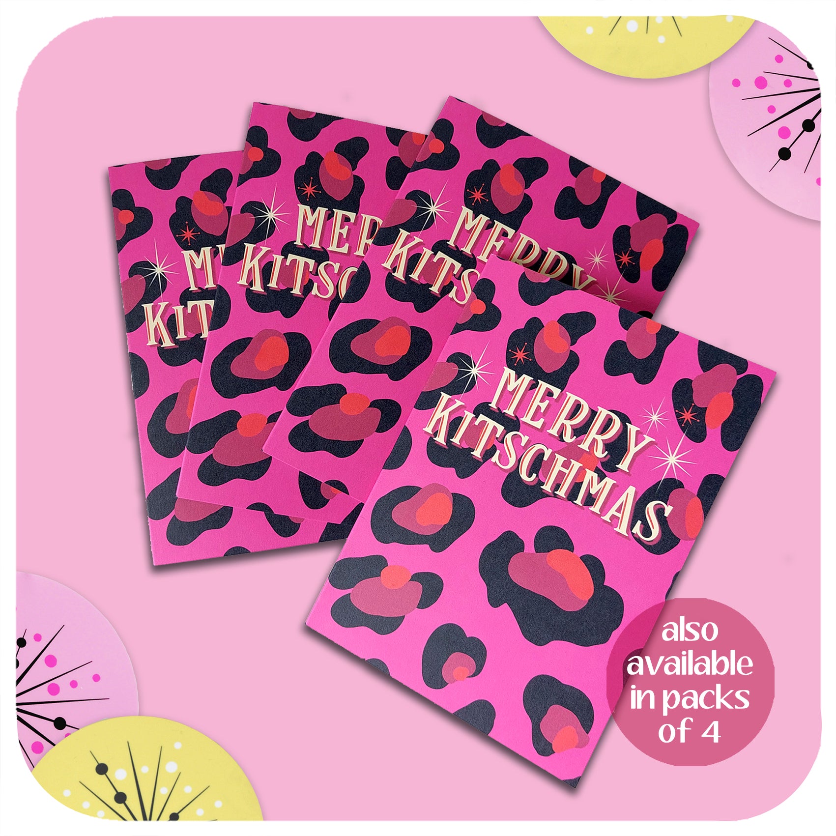 Four pink leopard print christmas cards lie on a pink background with retro style christmas decorations. Text on the cards reads: Merry Kitschmas.