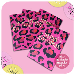 Four pink leopard print christmas cards lie on a pink background with retro style christmas decorations. Text on the cards reads: Merry Kitschmas.