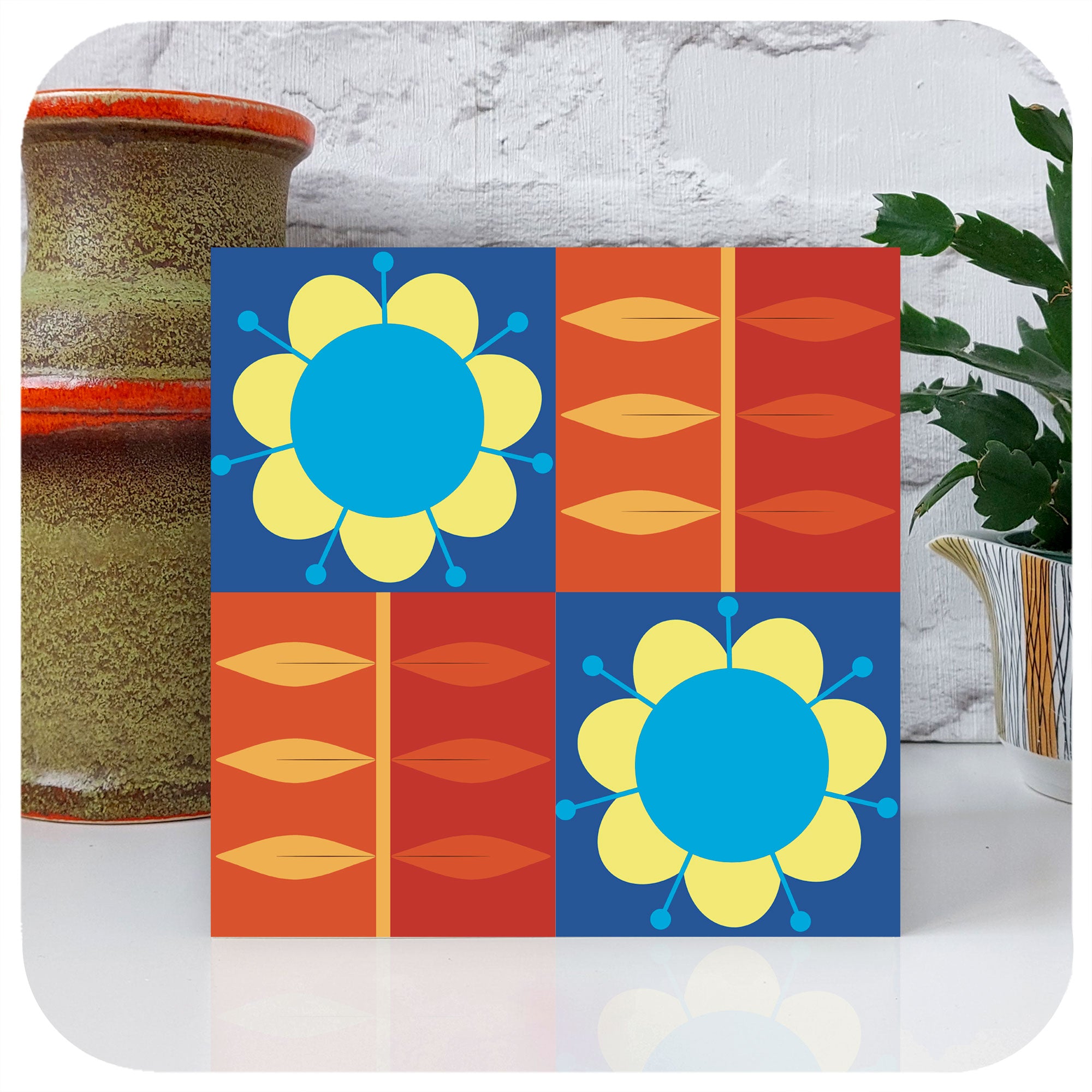 A square greetings card, with retro flowers in a grid pattern, stands with a vintage vase and potted cactus | The Inkabilly Emporium