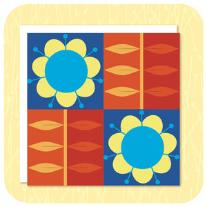 A square greetings card, with retro flowers in a grid pattern, lies on a textured yellow background with a white envelope. | The Inkabilly Emporium