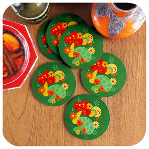Set of 6 Round, Retro Mushrooms Coasters lie in a scattered pile with various vintage pottery pieces, on a teak table | The Inkabilly Emporium