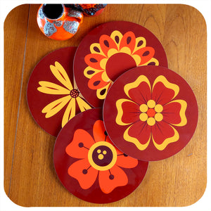 A set of four round 70s floral placemats on teak table with fat lava vases | The Inkabilly Emporium