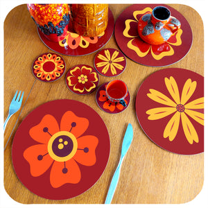 A set of four round 70s floral placemats on teak table with matching coasters and  vintage fat lava vases | The Inkabilly Emporium