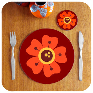A single round 70s floral placemat on teak table with coaster and cutlery, fat lava vase | The Inkabilly Emporium