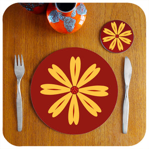 A single round 70s floral placemat on teak table with coaster and cutlery, a fat lava vase accompanies | The Inkabilly Emporium