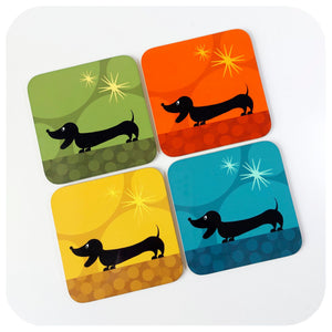 Four colourful coasters with dachshund illustrations on a white background