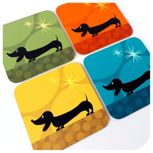 Four colourful coasters with black dachshund illustrations on a white background