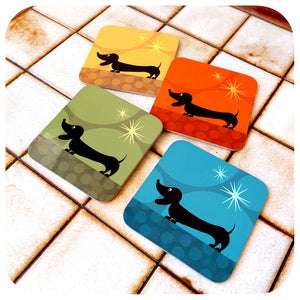 Four colourful coasters with dachshund designs on a tiled coffee table
